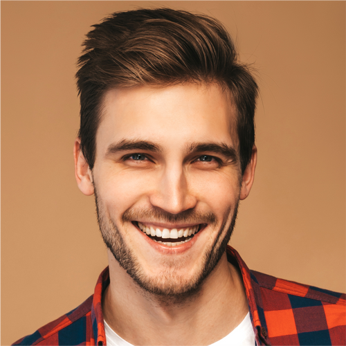 Close-up of a smiling man with thick, neatly styled brown hair and light stubble.
